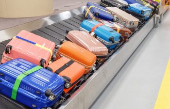 Bright colorful suitcases and bags on luggage conveyor belt