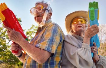 Two older people join a water fight