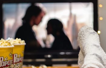 Young woman watching watching a movie with popcorn.
