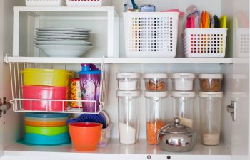 Food storage containers and their lids are stored in a cupboard.